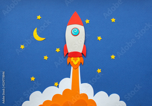 Fototapeta Naklejka Na Ścianę i Meble -  Rocket takes off into space. Night starry sky and clouds. Moon. Cartoon handmade paper art and cutting illustration. 
