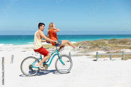 Young couple with bike at the beach