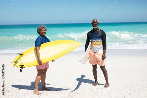 Old couple with surfboard at the beach