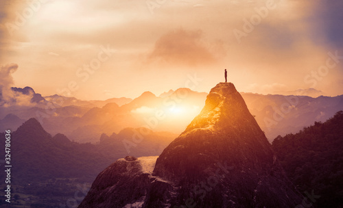 Peak Panoramic view on foggy mountains hills Successfully achieving your goal, Silhouette male on the mountain. Success Business Leadership, Winner Man on top. Business Sport and active life concept