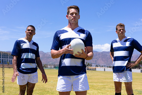 Rugbymen standing with ball