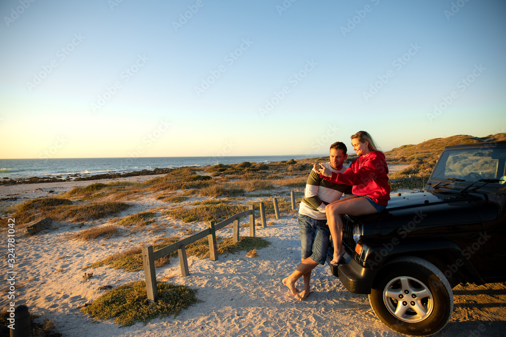 Obraz premium Couple with car at the beach