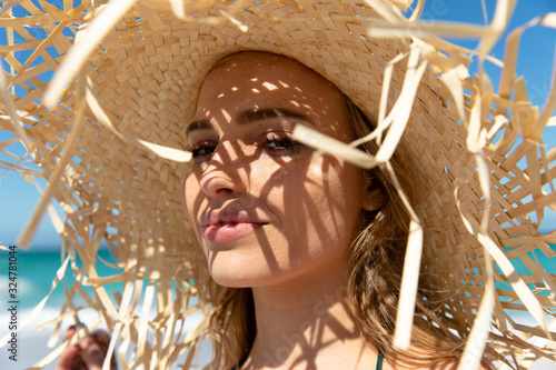 Young woman with straw hat at the beach