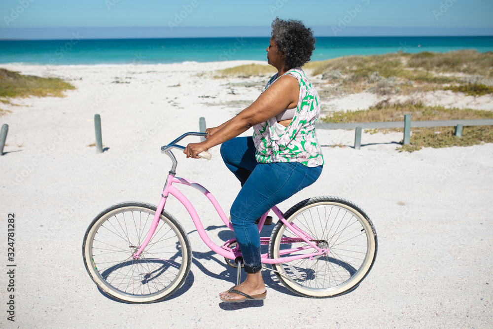 Old woman with a bike at the beach