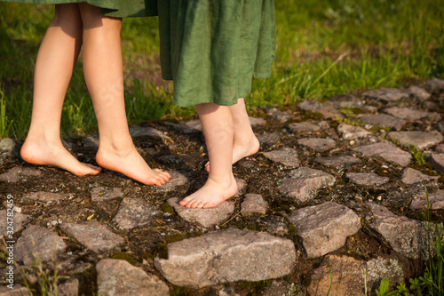 Bare girls feets on a stone path in a park