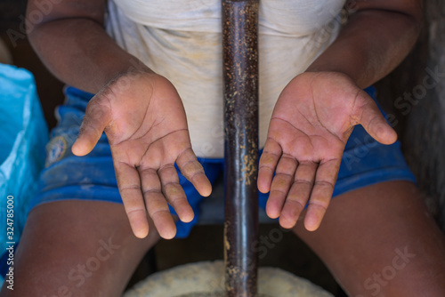 Hands of a black woman in close up who is crushing stones to obtain clay on the Island of Sao Vicente in Cape Verde