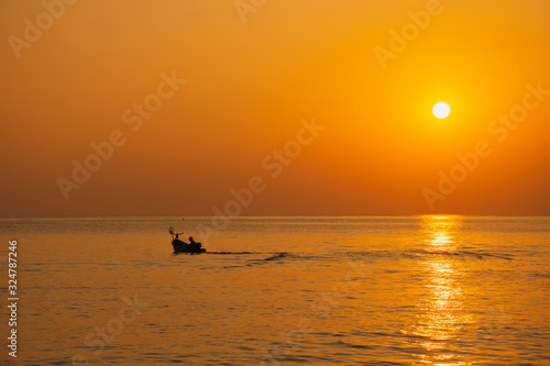 Black silhouette, beautiful sunset with a fishing boat, Mae Ramphueng Beach, Rayong Province, Thailand © Anurak