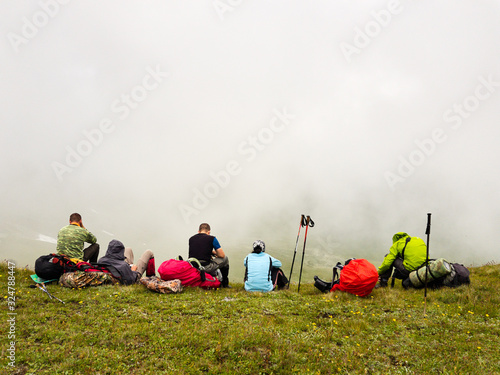 Hikers have a rest on a hillside and enjoy the view