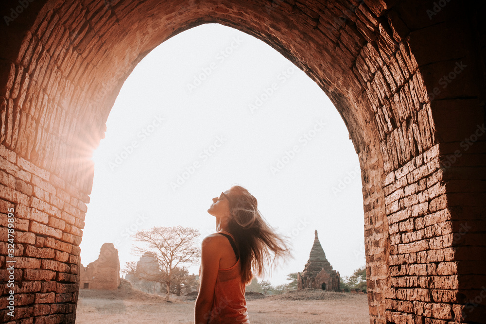 Young Woman enjoying an amazing sunset in Bagan - obrazy, fototapety, plakaty 