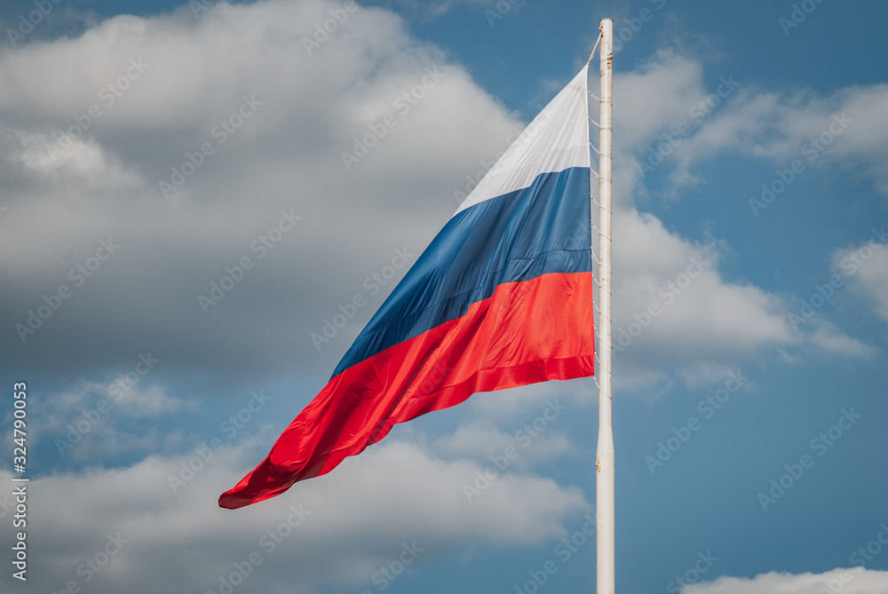 Fototapeta premium Limp Russian flag on the background of blue sky,