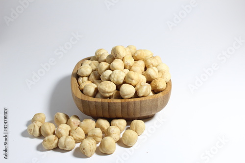 hazelnut in a wooden bowl isolated on white background