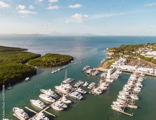 Marina town with waterfront river view of yachts and boats in sea water. Carins Port Douglas aerial view. Dramatic DRONE view from above. Mountain landscape in background. Queenstown, Australia. photo