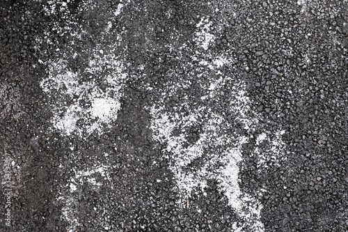 De-icing chemicals on the asphalt pavement. Pavement is sprinkled with technical salt or salt mixtures based on it. photo