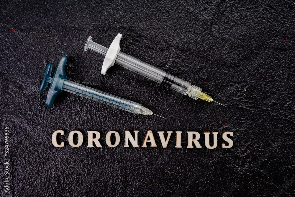 Coronavirus vaccine vial with injection syringe isolated on black background Coronavirus vaccine vial with injection syringe isolated on black background