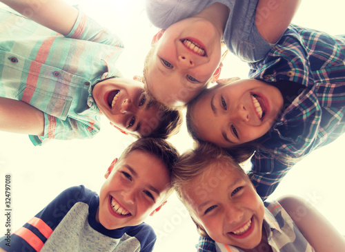 childhood, leisure, friendship and people concept - group of smiling happy children faces in circle