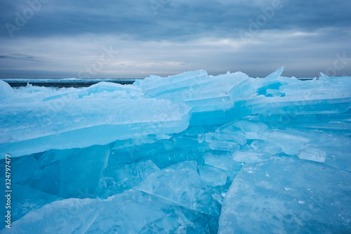 Field of ice hummocks on the frozen lake. Cracked ice on lake in winter season, natural landscape background.