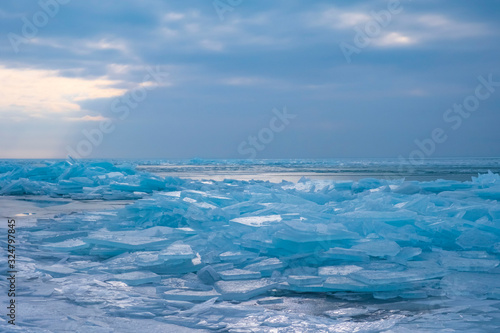 Field of ice hummocks on the frozen lake. Cracked ice on lake in winter season  natural landscape background.