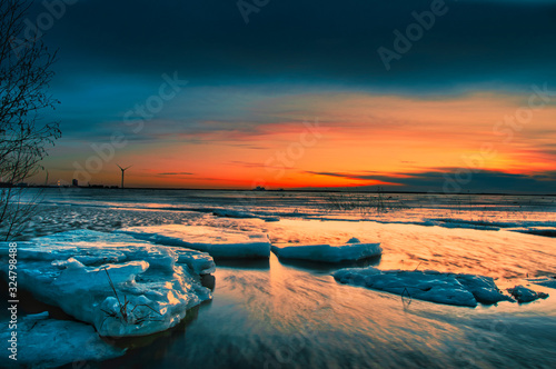 Fototapeta Naklejka Na Ścianę i Meble -  Icy landscape by seashore in sunset.