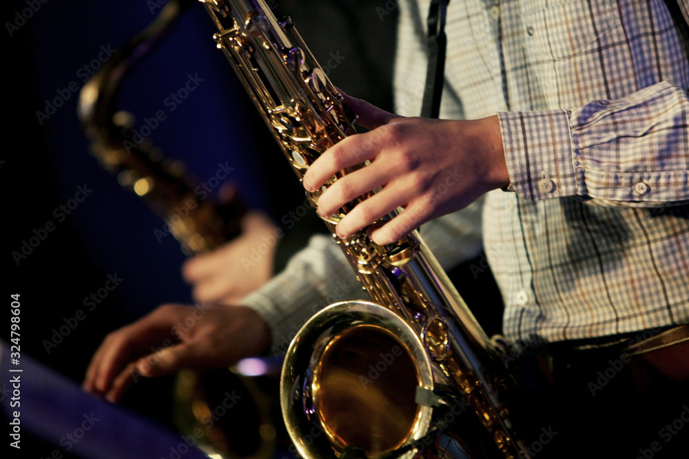 Obraz premium Hands of tenor saxophone player on the stage