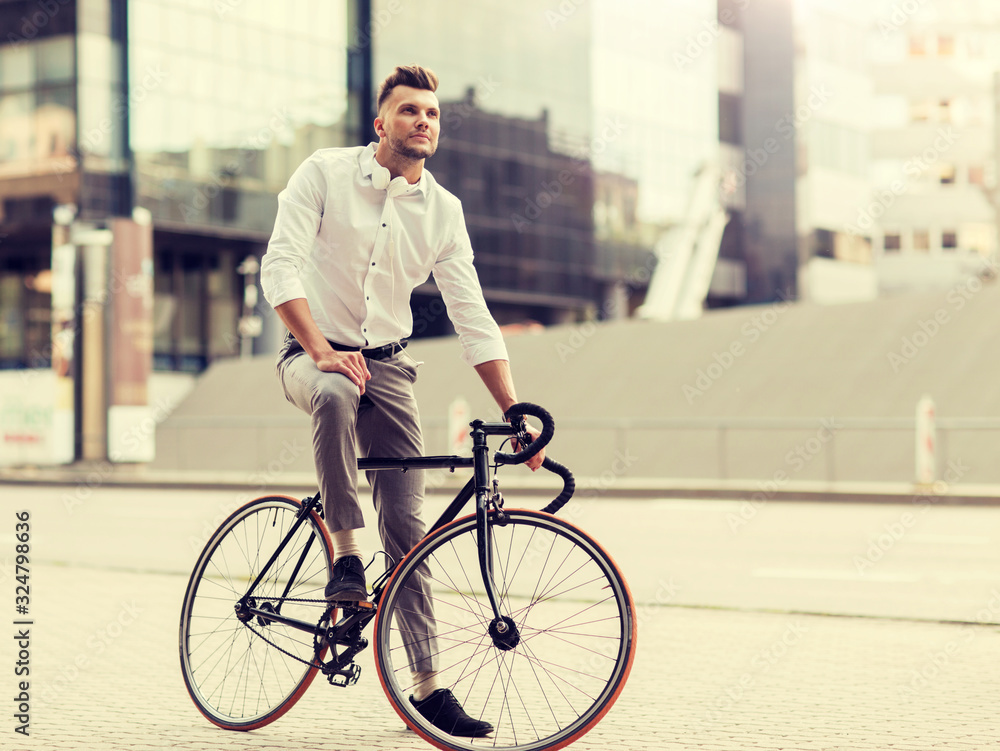 lifestyle, transport and people concept - young man with bicycle and headphones on city street lifestyle, transport and people concept - young man with bicycle and headphones on city street