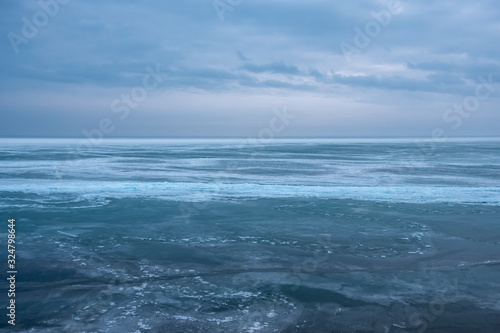 Field of ice hummocks on the frozen lake. Cracked ice on lake in winter season, natural landscape background. © Adil
