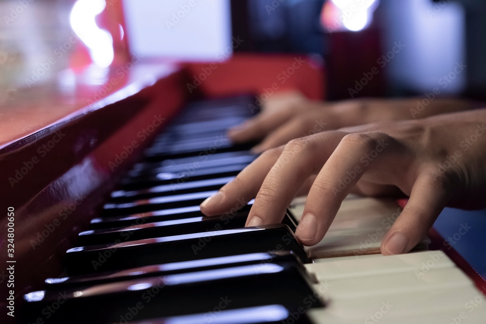 Obraz premium Woman's hands on the keyboard of the piano closeup. Hands musician playing the piano closeup.