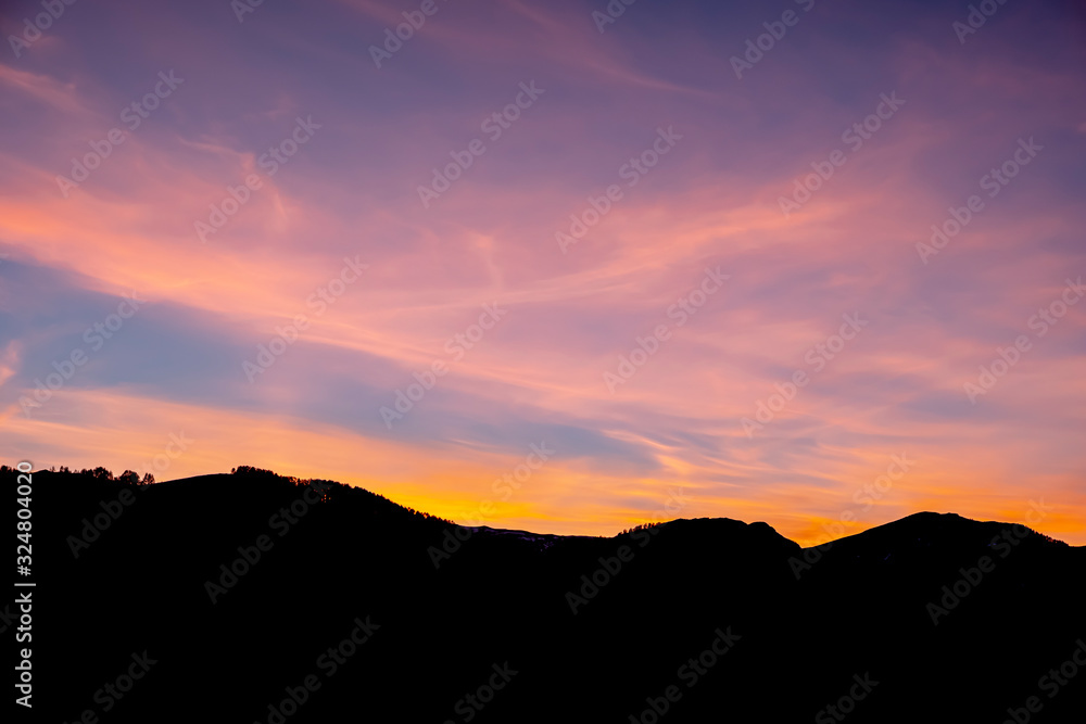 Beautiful colorful sky with mountain silhouette. Sunset in the mountains.
