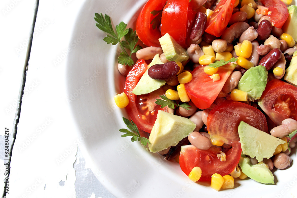 Mexican-style vegetable salad with beans, avocado, tomatoes, corn, and chickpeas