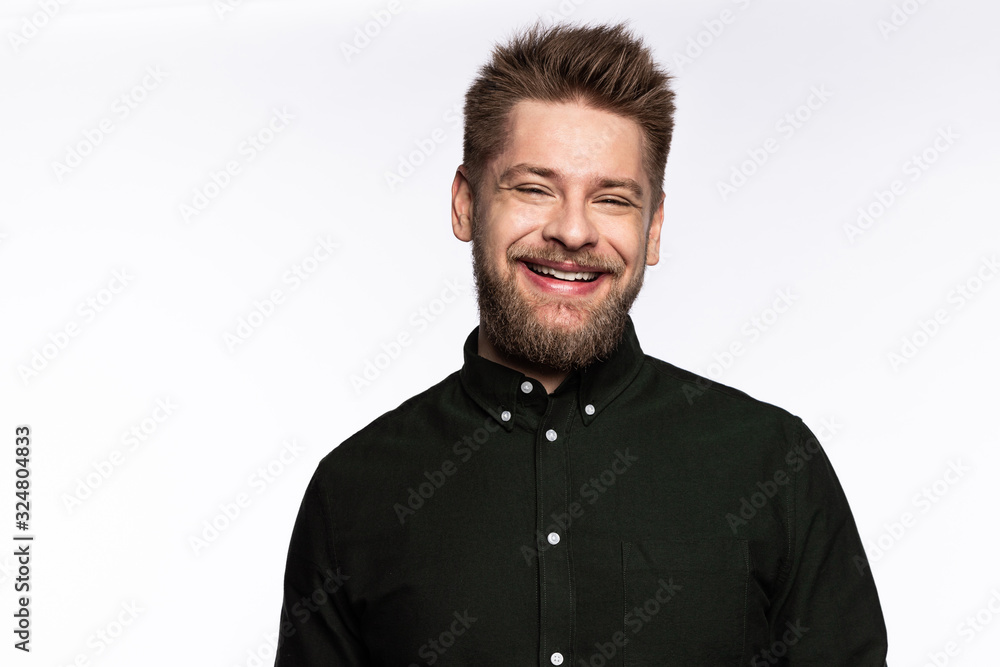 Fototapeta premium Handsome bearded guy looking at camera and smiling on white background.