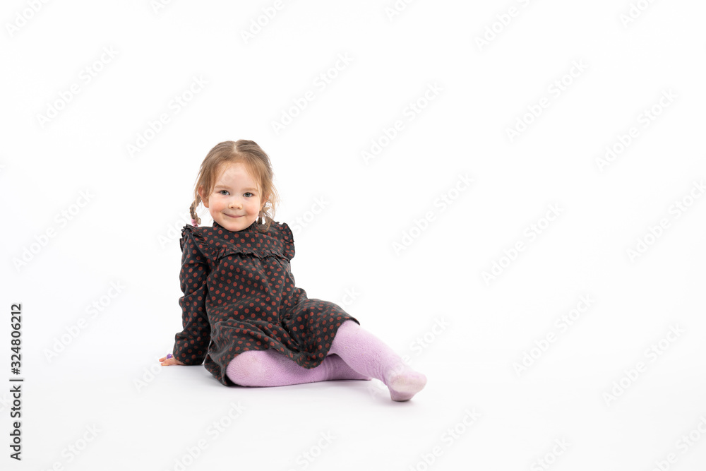 Funny redhead girl in purple tights sitting on the floor and looking at the camera isolated over white background Funny redhead girl in purple tights sitting on the floor and looking at the camera isolated over white background