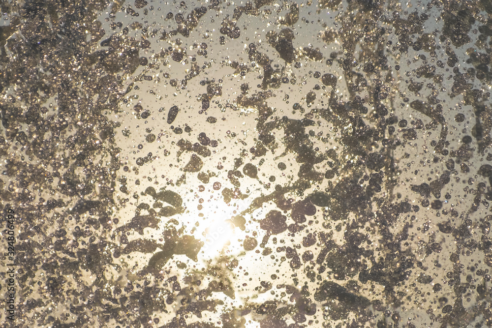 Splashing water fountain against sun and clear sky. Splashing water fountain against sun and clear sky.