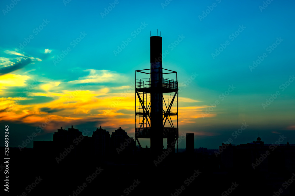 Beautiful sunset with gold cloudy sky and silhouettes of buildings and industrial pipes. Beautiful sunset with gold cloudy sky and silhouettes of buildings and industrial pipes.