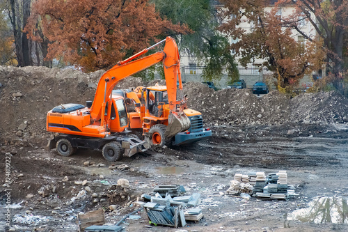 Orange excavator and wheel loader in a construction site.