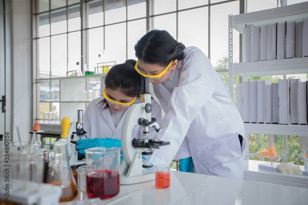 Medical Research and Scientists are working with a microscope and a tablet and Test Tubes, Micropipette and Analysis Results in a laboratory. Medical Research and Scientists are working with a microscope and a tablet and Test Tubes, Micropipette and Analysis Results in a laboratory.