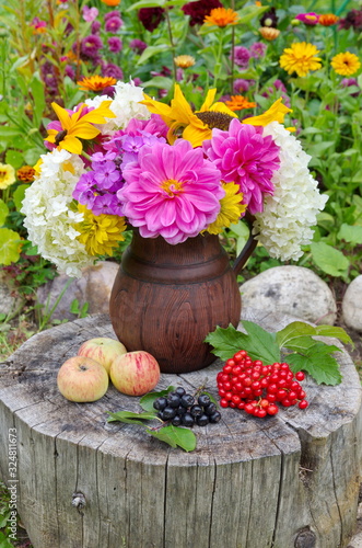 bouquet of flowers in basket on wooden background