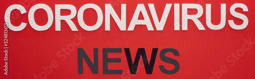 Top view of coronavirus news lettering isolated on red, panoramic shot