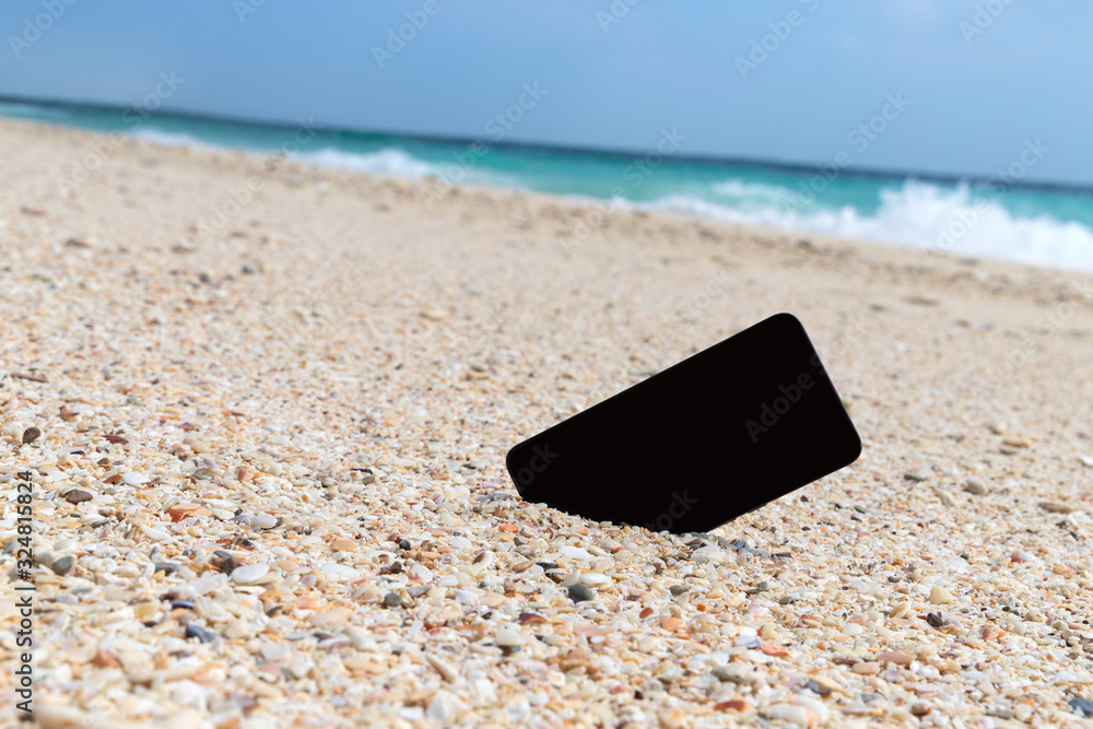 Smart phone with empty screen on tropical sand beach background Smart phone with empty screen on tropical sand beach background