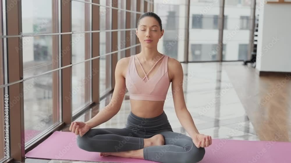 girl practices yoga on the rug of breathing belly