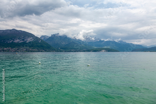 Beautiful view on french Alps at lake Annecy, France. Coudy sky.
