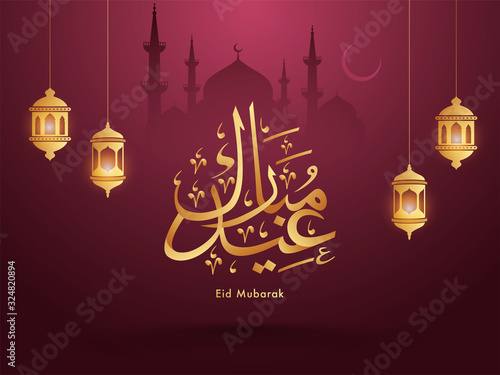 Golden Eid Mubarak Calligraphy in Arabic Language with Hanging Illuminated Lanterns and Mosque on Burgundy Background.