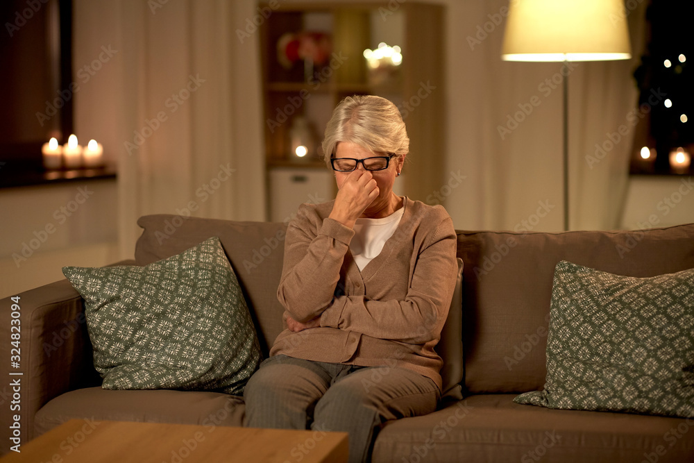 old age, vision and people concept - tired senior woman in glasses rubbing her eyes at home at night old age, vision and people concept - tired senior woman in glasses rubbing her eyes at home at night