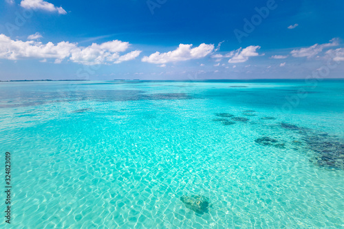 Tropical sea backdrop. Beautiful white clouds on blue sky over calm sea with sunlight reflection. Tranquil sea harmony of calm water surface. Sunny sky and calm blue ocean.