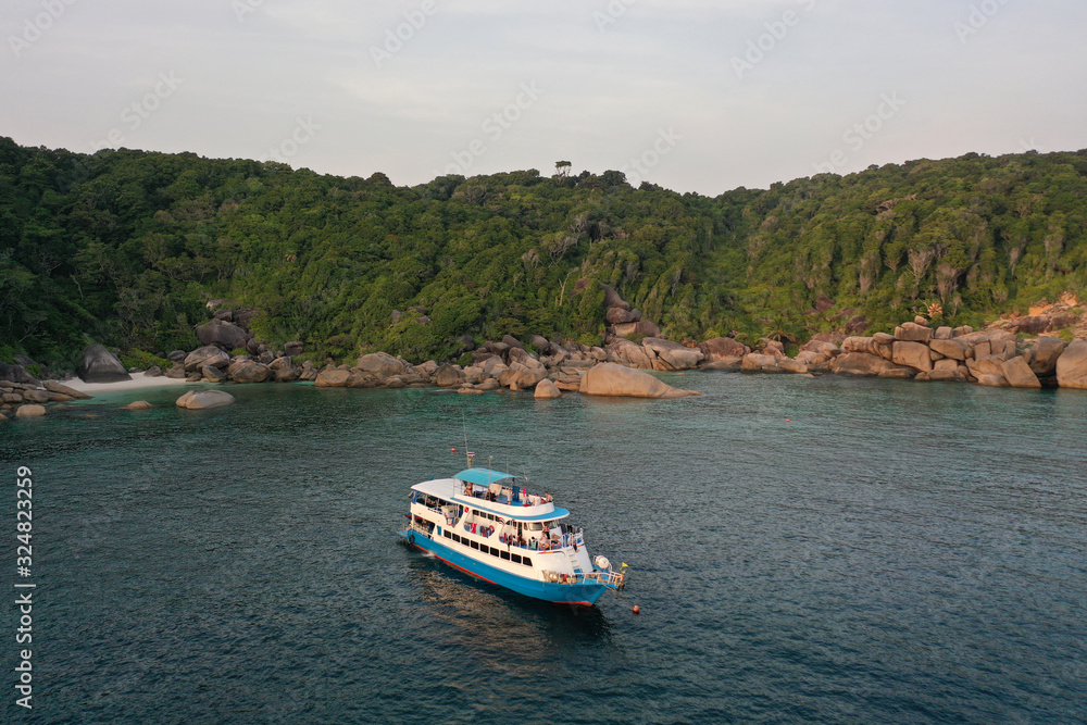 Scuba diving liveaboard boat beside tropical island 