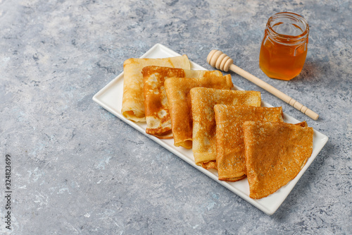 Delicious Breakfast on light background. Orthodox holiday Maslenitsa. Crepes with cumquats and honet,top view