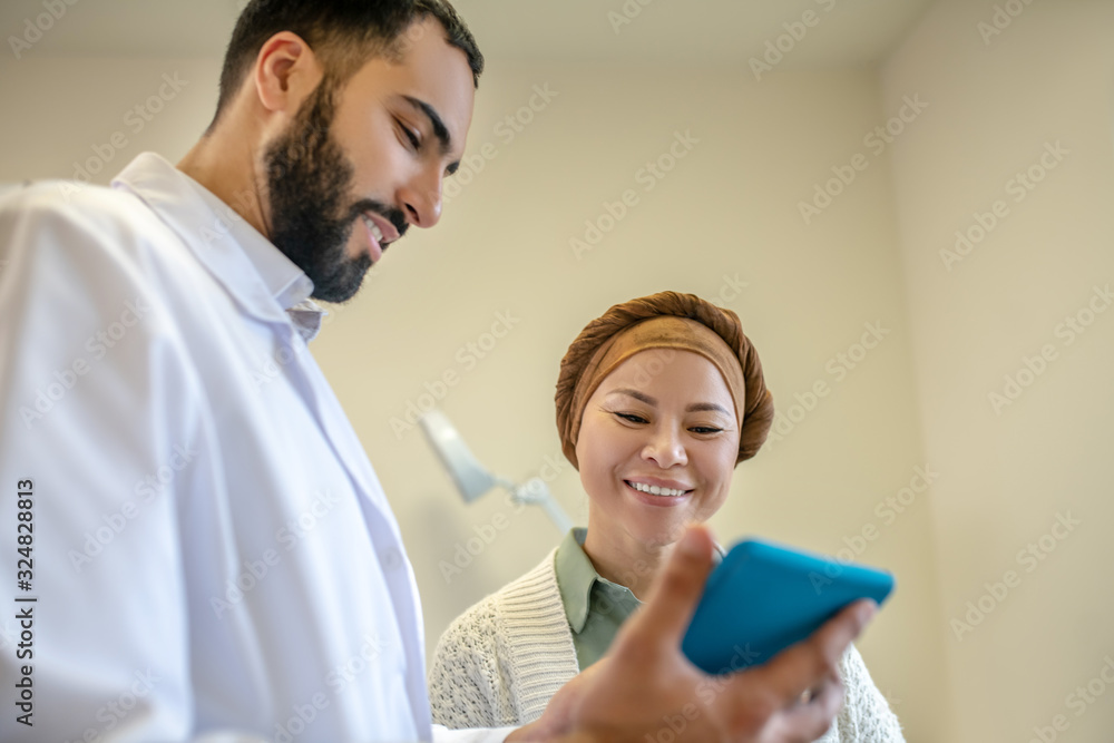Fototapeta premium Bearded young doctor and his patient talking
