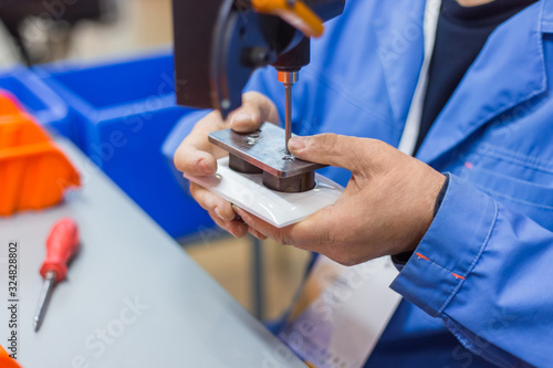 Blind man assembler, electrician hands assembling electric socket at fabric. Repair, production, handmade manufacturing process, electricity and disabled people concept