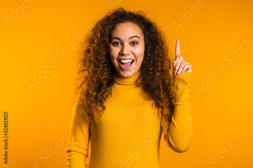 Foto Portrait of young thinking pondering woman having idea moment pointing finger up