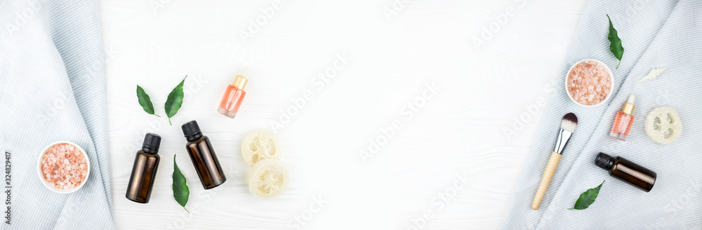 Banner made from homemade spa cosmetic set with salt and oil on white wooden background. Copy space. Flat lay style.