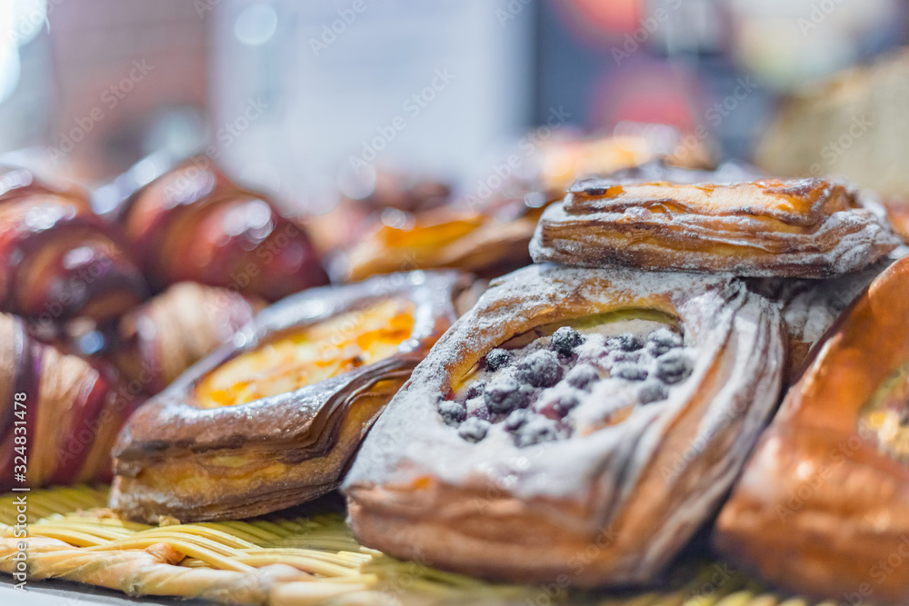 Close up view - assortment of delicious freshly baked sweet and puff pastry for sale on counter of shop, grocery, market, cafe or bakery. Dessert, food and traditional french cuisine concept