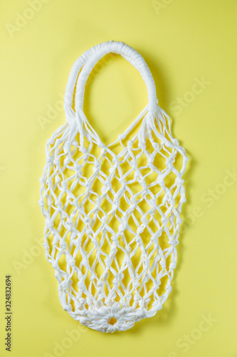 Reusable mesh shopping bag. Empty net bag on yellow background